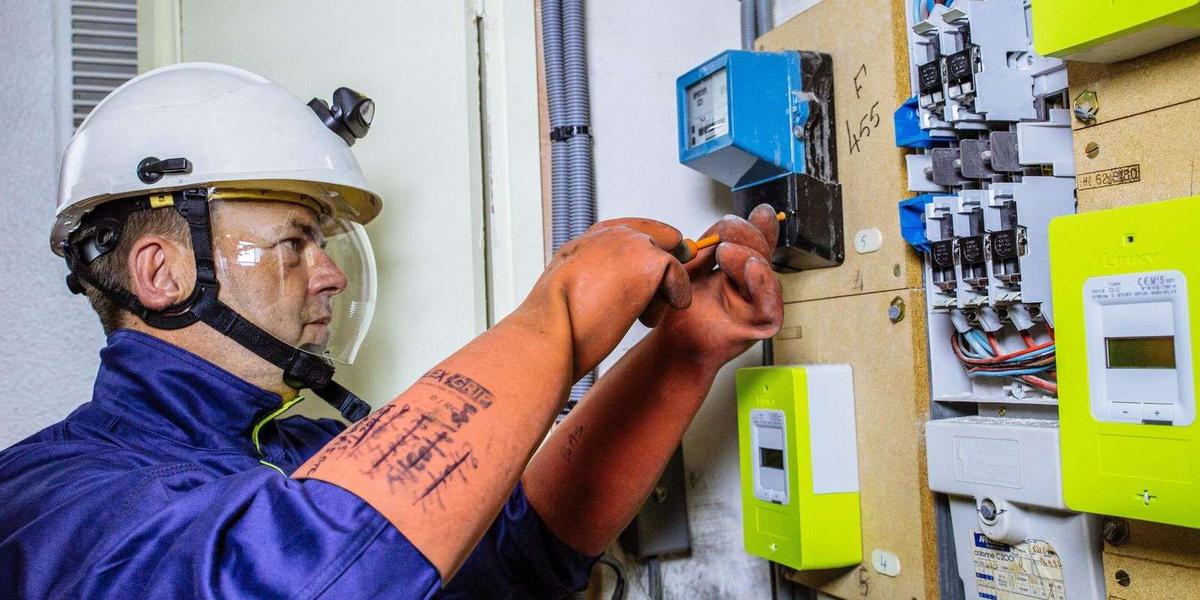 Technicien Enedis réalisant une mise en service électricité sur un compteur dans un local technique