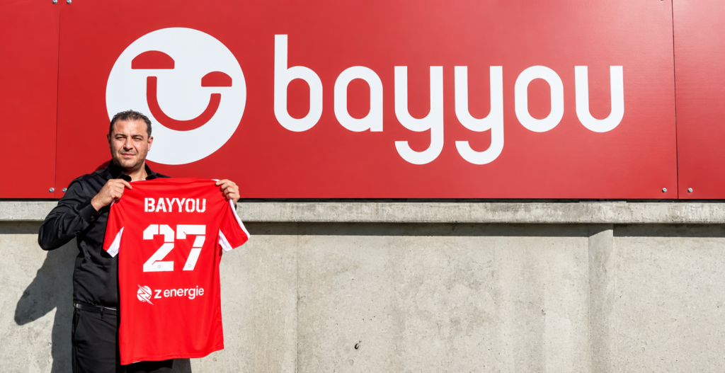 Skander Ayari, dirigeant de BAYYOU présentant le maillot du club dans le stade.